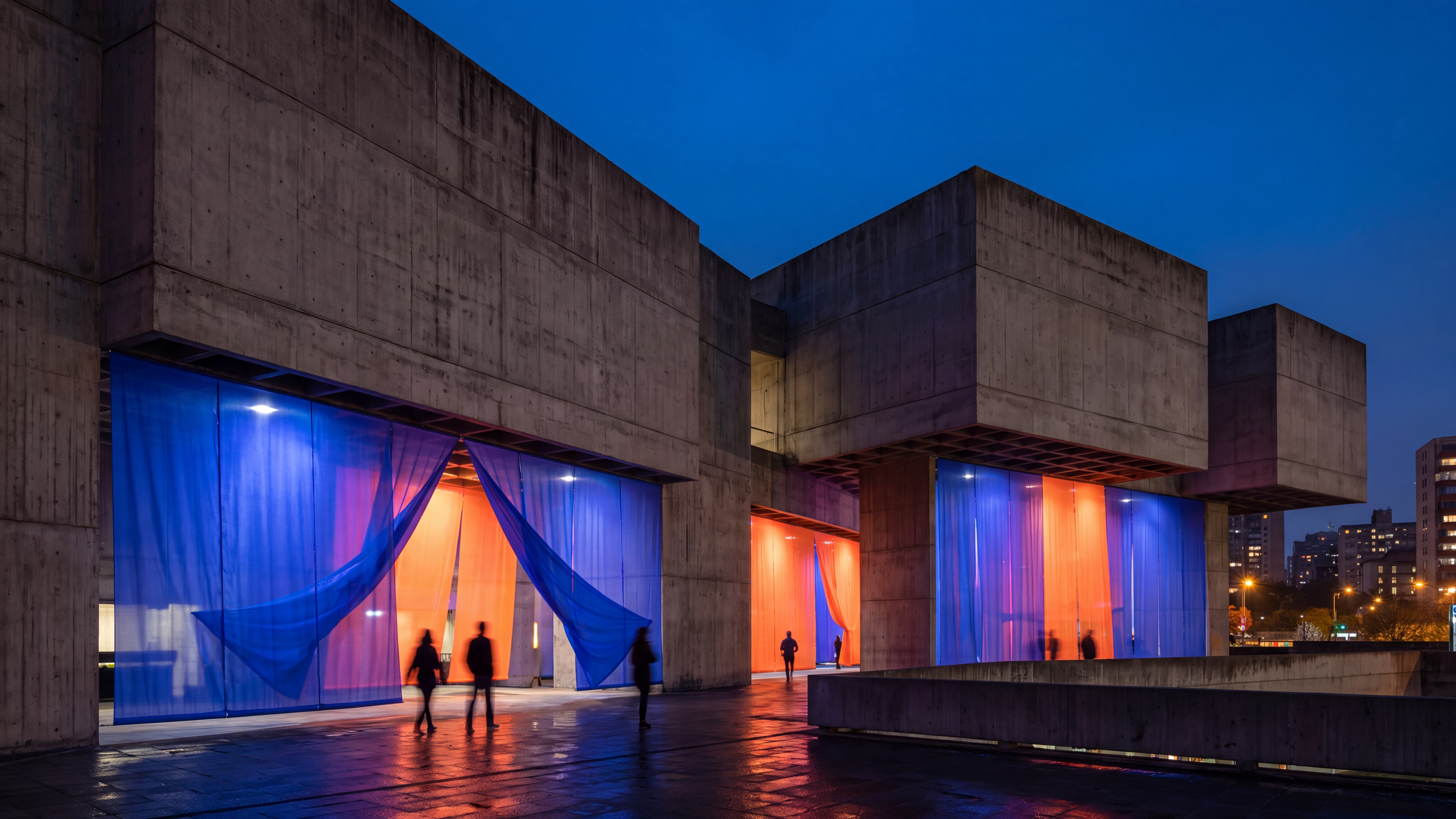 Cobalt and orange scrims divide a raw concrete screening hall.
