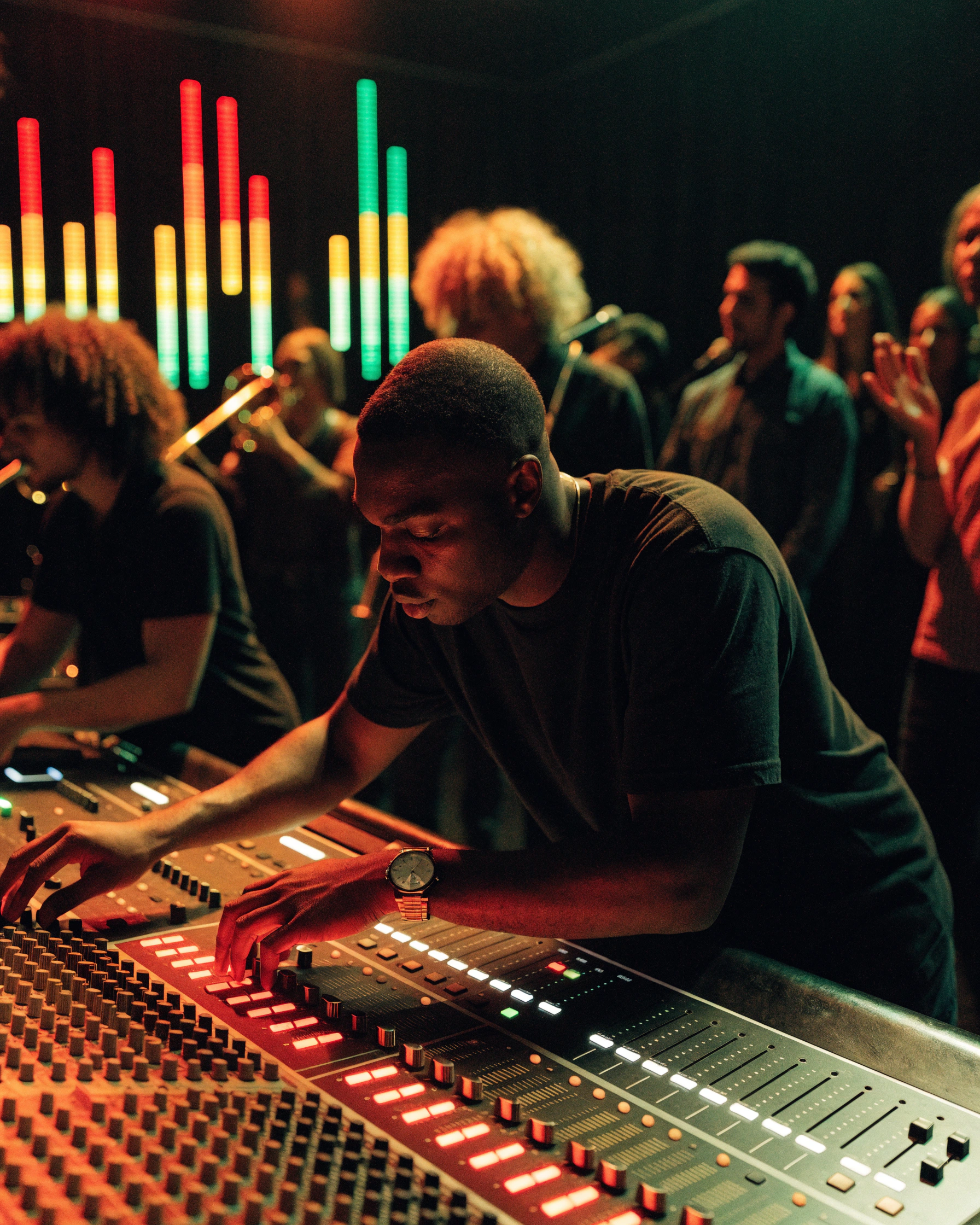 Real audio levels on a mixing desk correspond to the bars visible behind it.