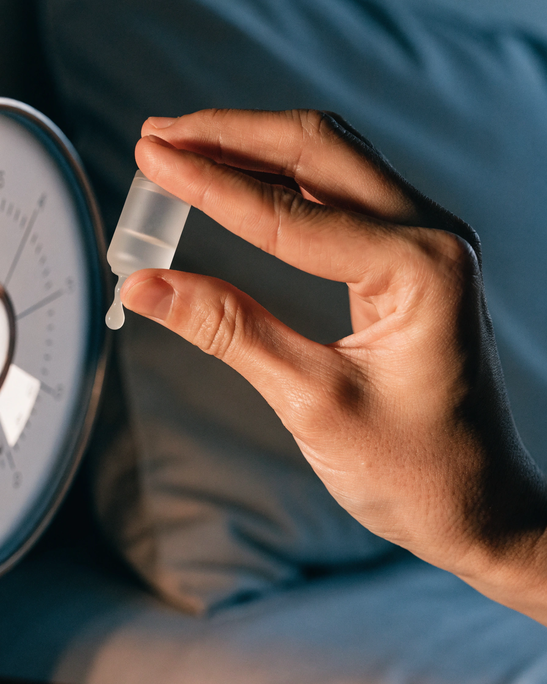 A fingertip dispenses the stated amount while the dial points to the current window.