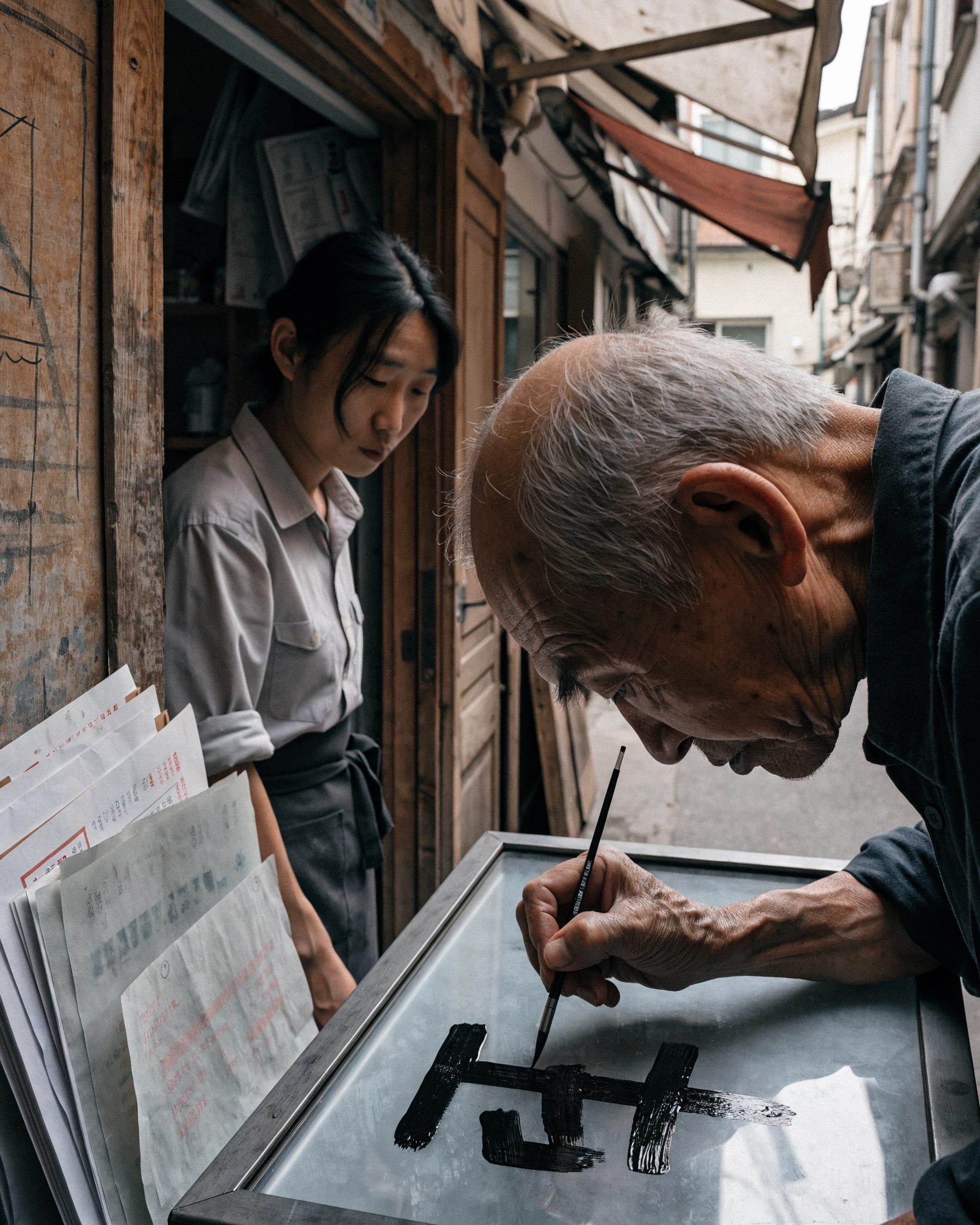 A sign painter repairs one Hangul stroke on an ageing storefront panel.