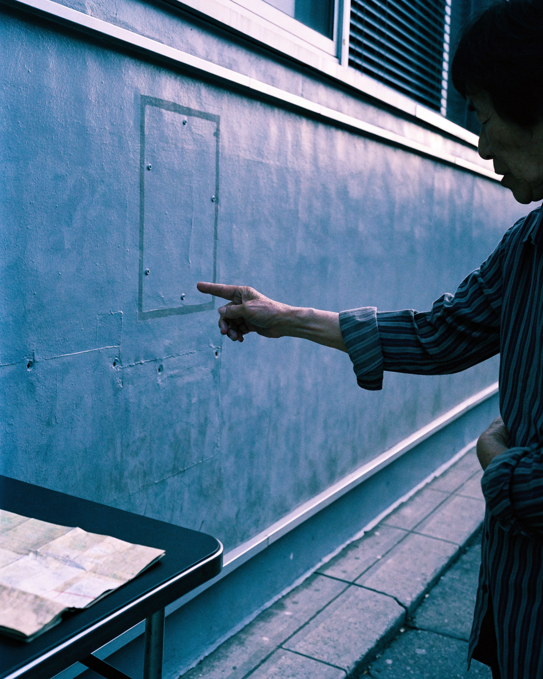 A resident points to the outline left by a removed storefront sign.