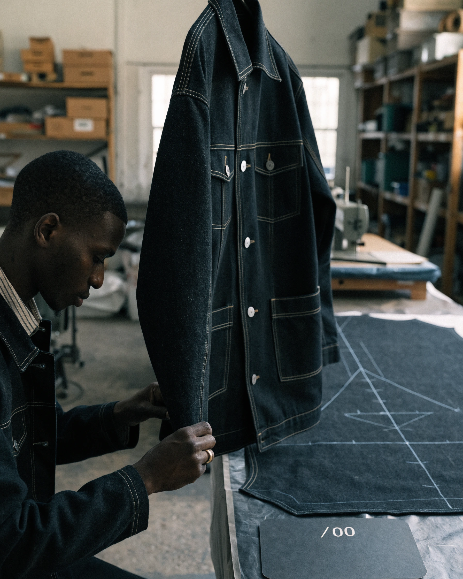 The original garment hangs beside its flat pattern and empty intervention record.